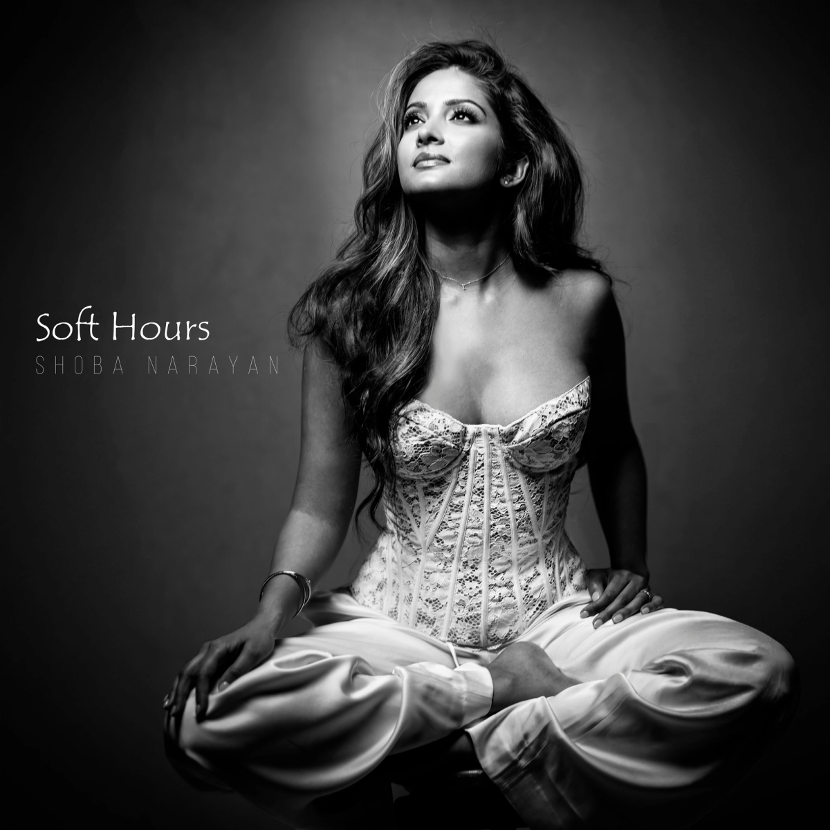 Black and white portrait of Shoba Narayan for her album "Soft Hours," wearing a white lace corset top and looking upward
