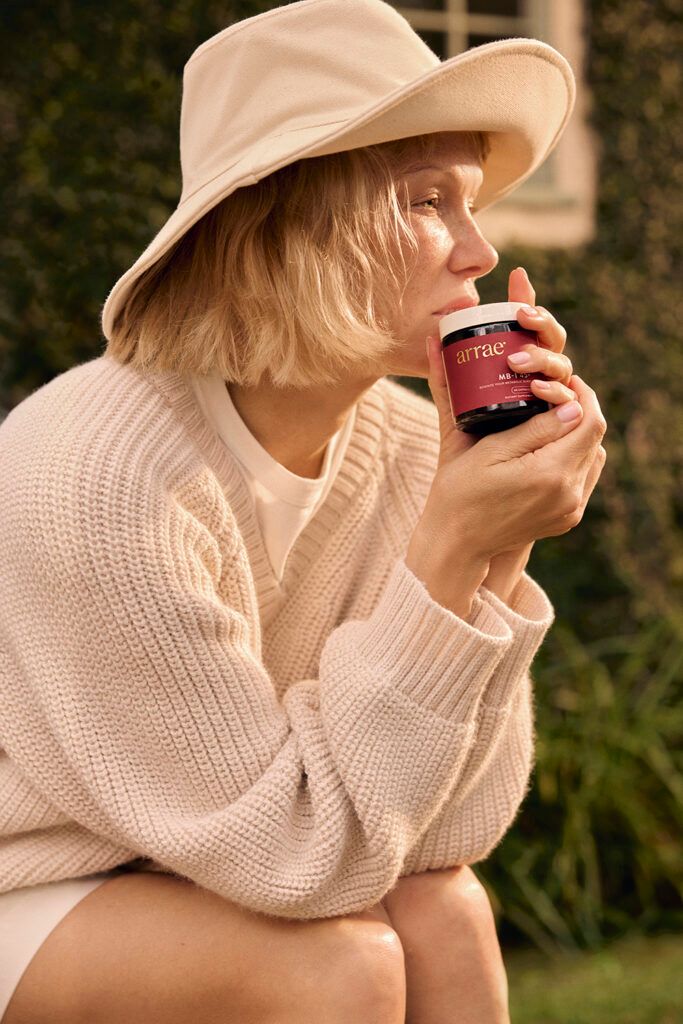 Pamela Anderson holding a jar of Arrae MB-1 45+ supplements