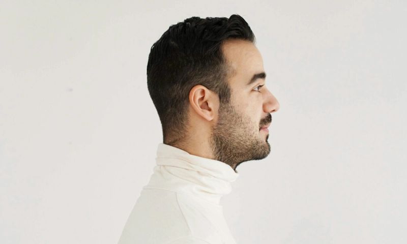side profile of man in a white turtleneck