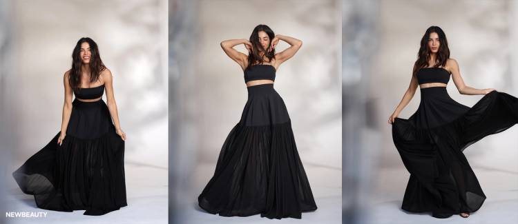 NewBeauty’s May digital cover star, Jenna Dewan, poses in a flowing black SIMKHAI two-piece look across three studio portraits, smiling, adjusting her hair and holding out the skirt.