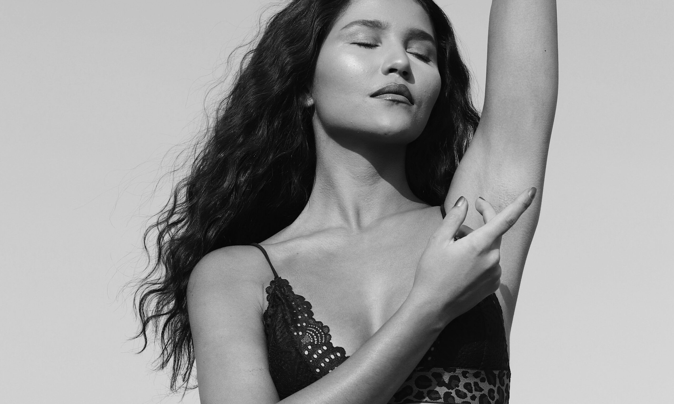 black and white image of woman with arms extended and eyes closed