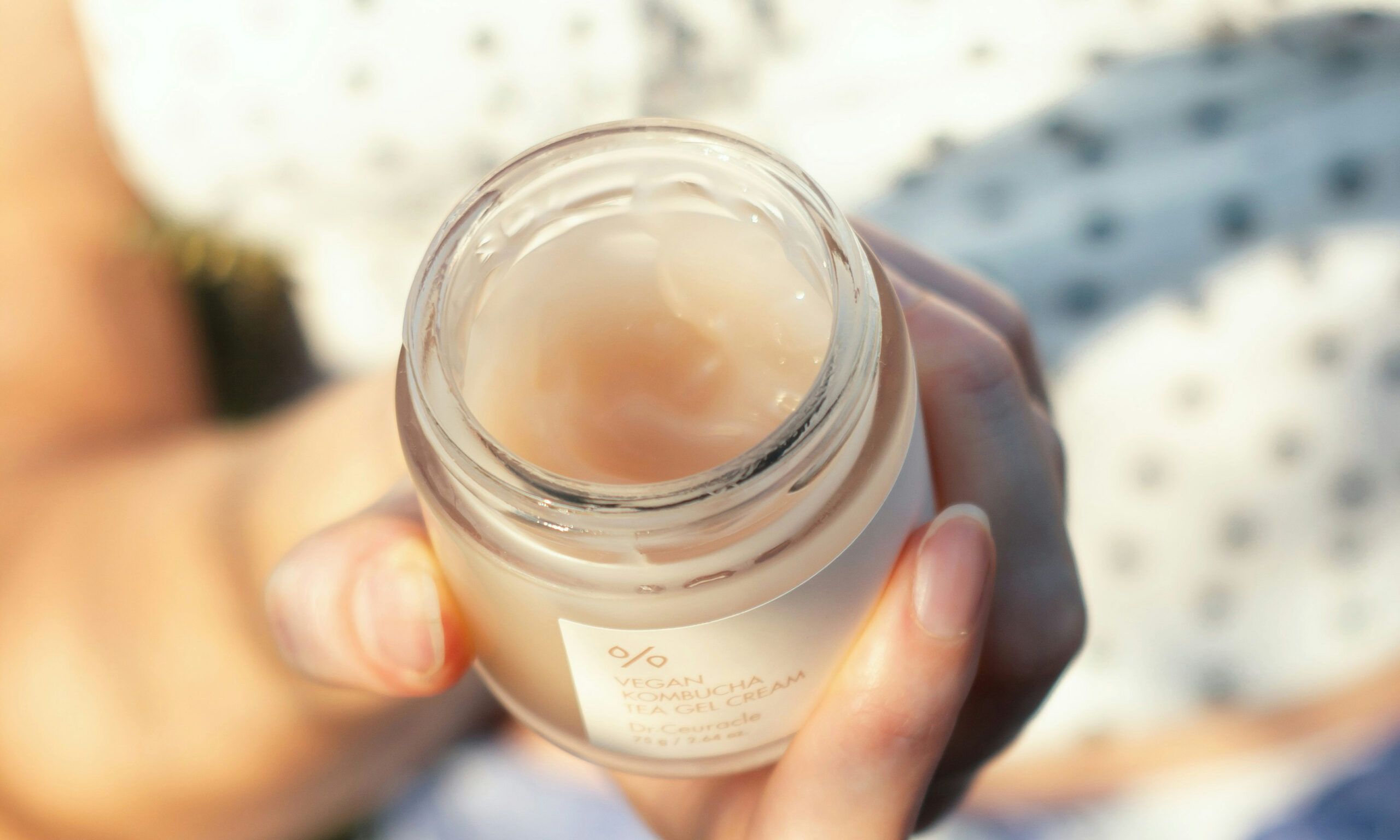 woman holding a jar of skin care cream