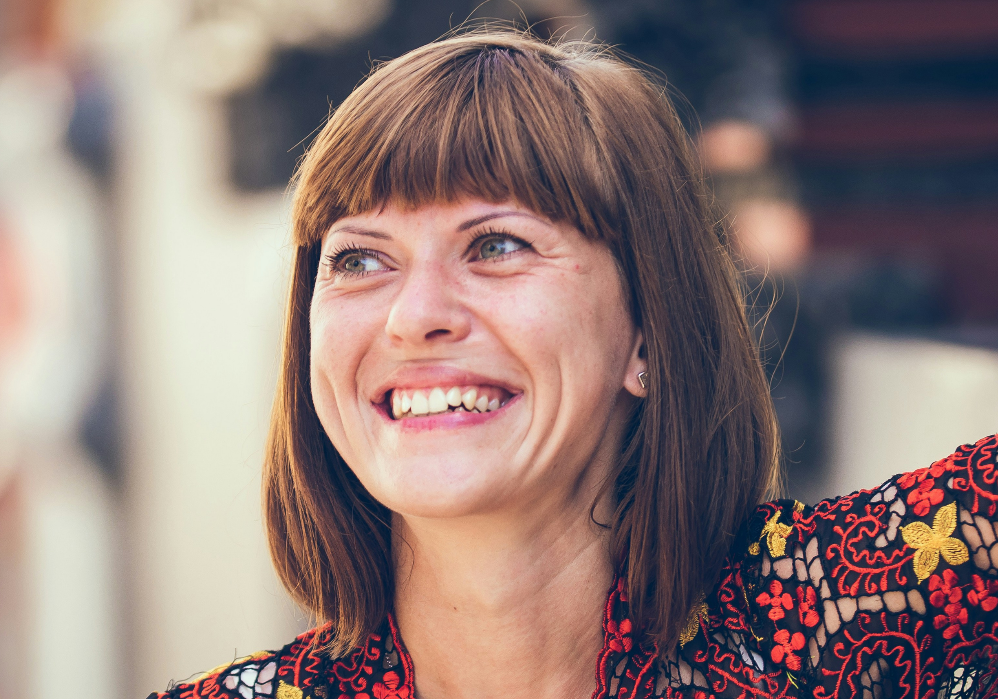 A woman in her 40s smiles wearing a soft pink lip and natural makeup