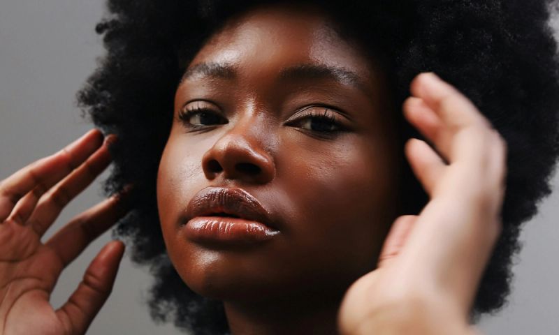 woman looking into the camera with hands reaching for face