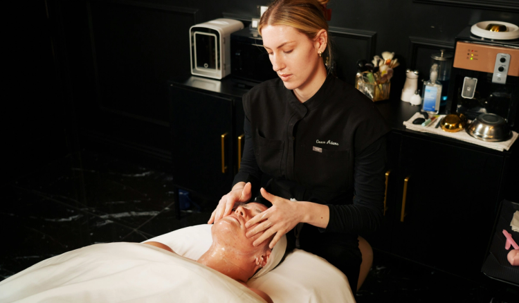 Aesthetician massaging a client’s face during a facial treatment in a spa.