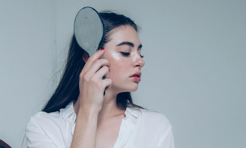 brown-haired woman brushing hair
