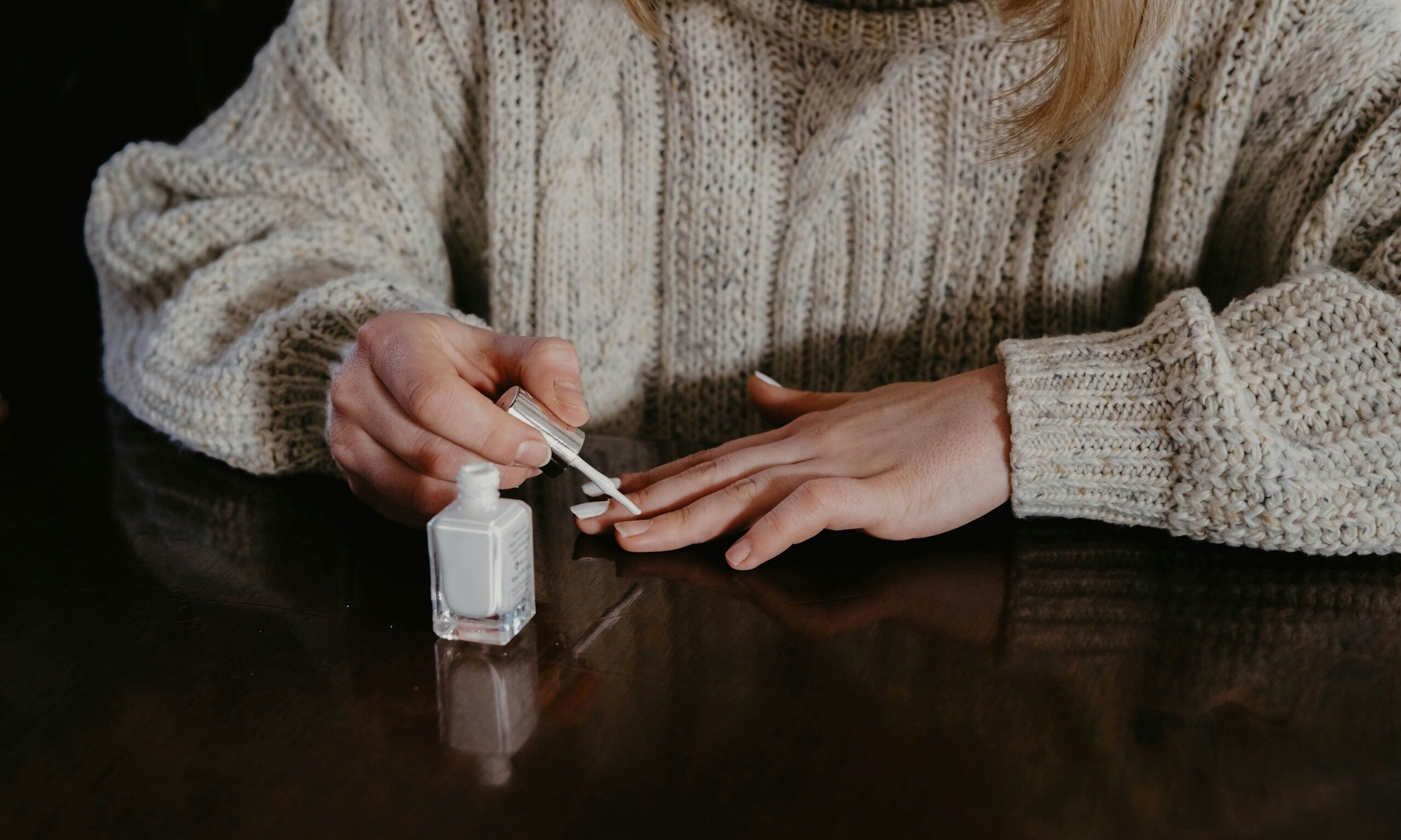 woman applying white nail polish