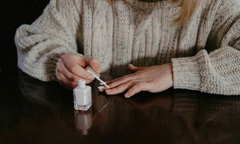 woman applying white nail polish