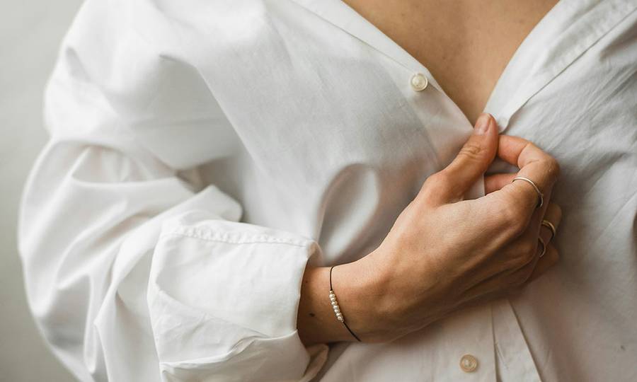 chest view of woman unbuttoning shirt