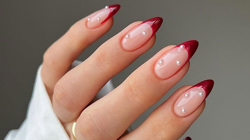 Dark red french tips with pearl accents.