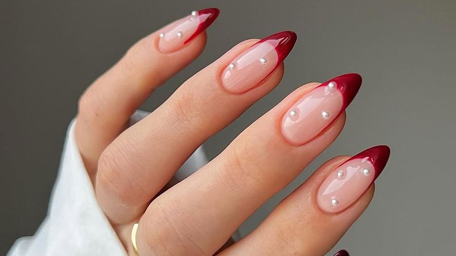 Dark red french tips with pearl accents.