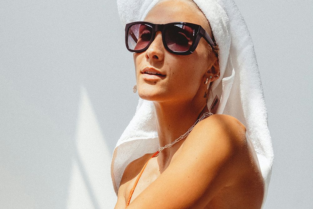 tan woman wearing towel on her head and sunglasses