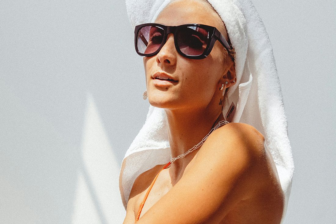 tan woman wearing towel on her head and sunglasses