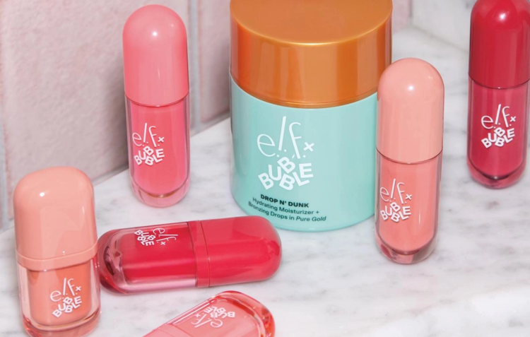 Assorted e.l.f. x Bubble makeup and skin-care products, including blush, lip and bronzing formulas, arranged on a marble surface.