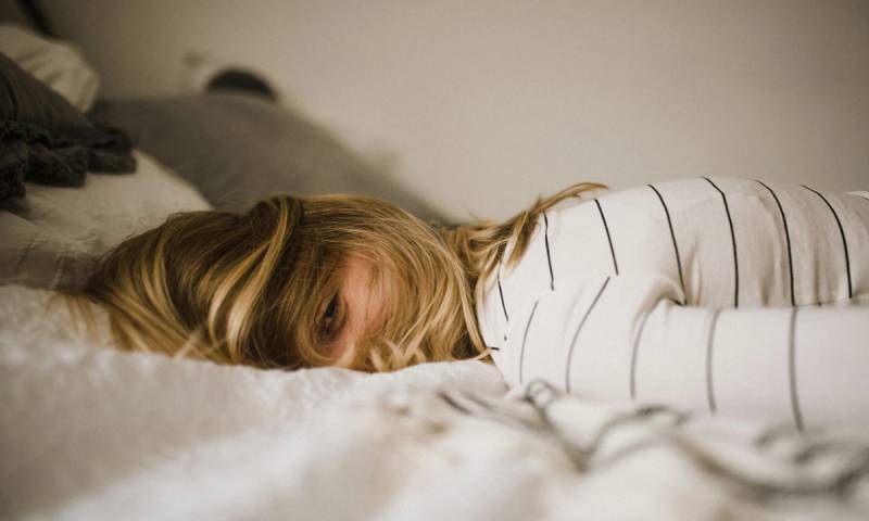 Woman laying face down on bed