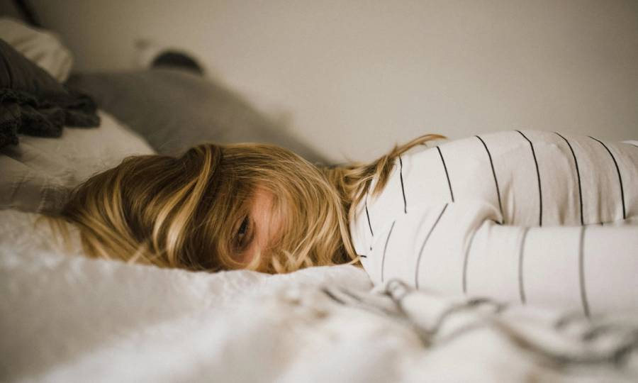 Woman laying face down on bed