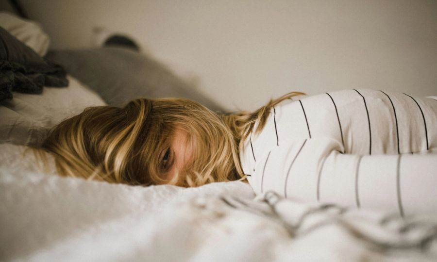 Woman laying face down on bed