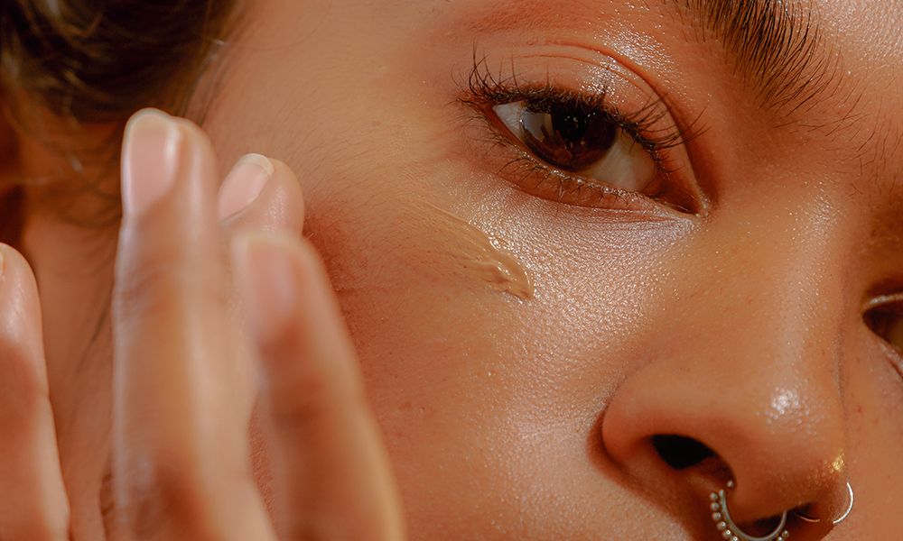 Closeup of a Young Confident Woman Applying Foundation