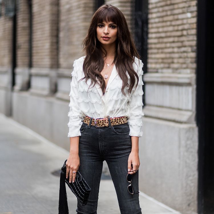 Emily Ratajkowski posing on the street with long brown hair and bangs