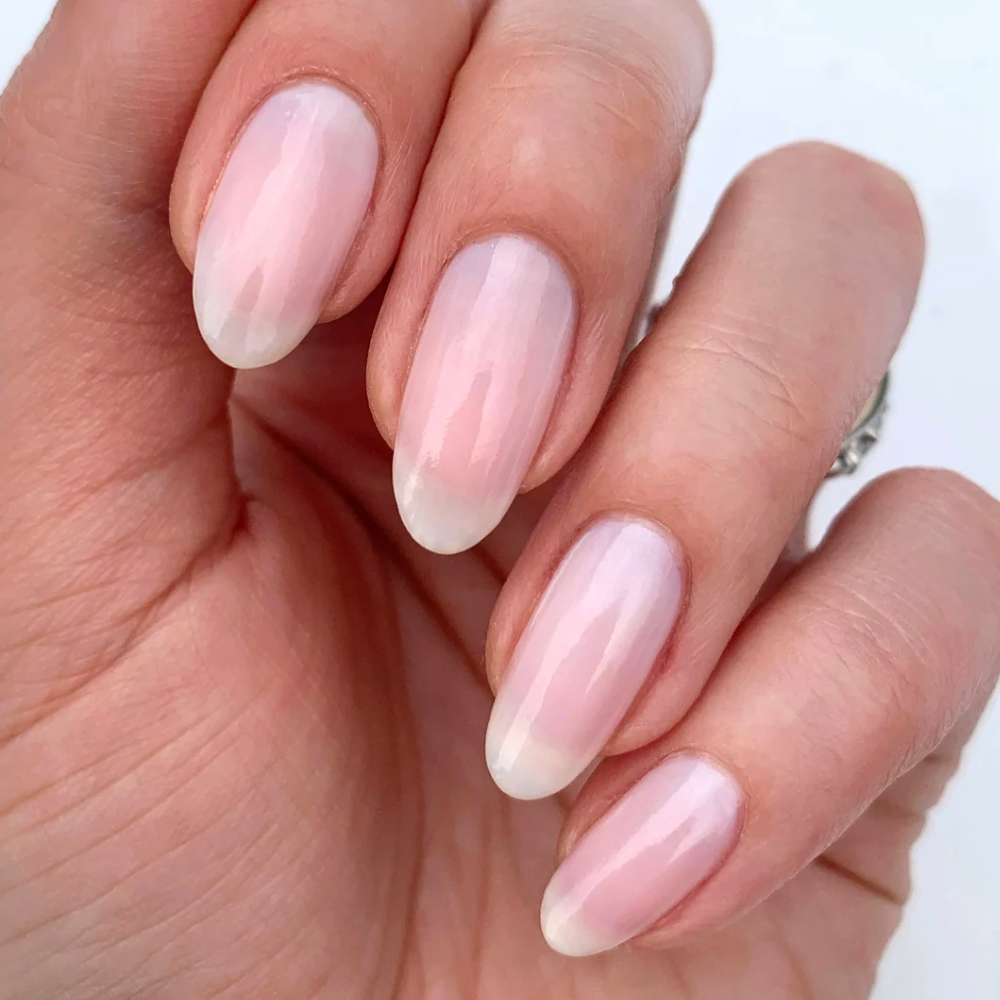 hand of woman with long nails and natural nail polish