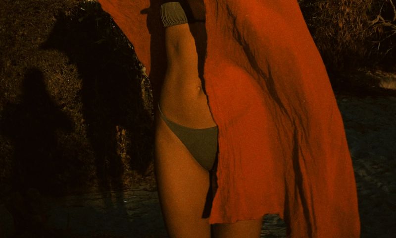 lower body of woman in bikini with orange towel