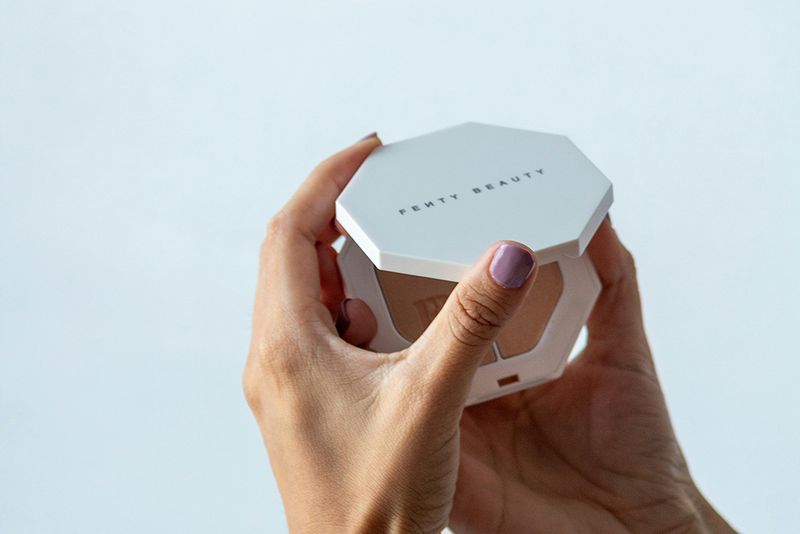 woman holding fenty beauty compact