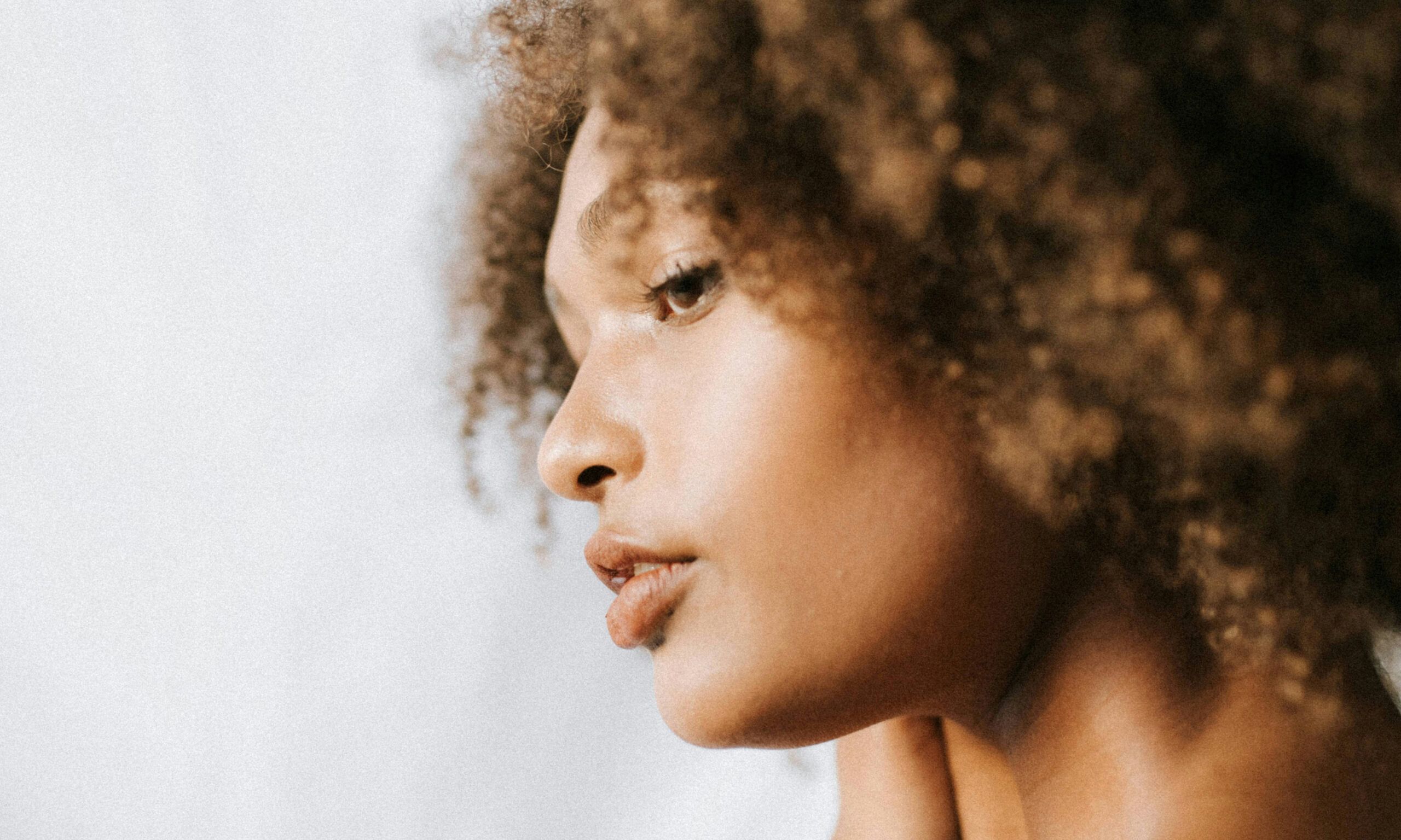side view of curly-haired Black woman's face