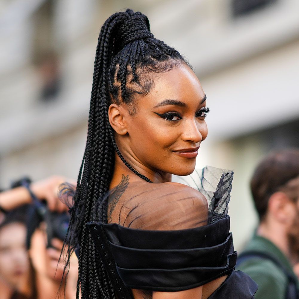 Woman wearing high knotless braided ponytail and black dress