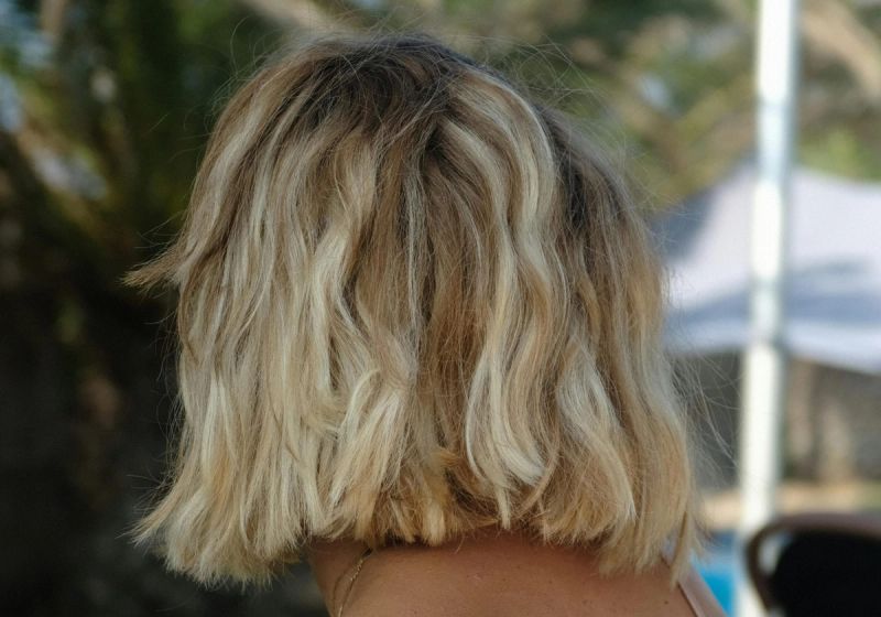 woman with short blonde hair in brown spaghetti strap top
