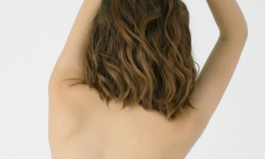 back view of topless woman with hands up