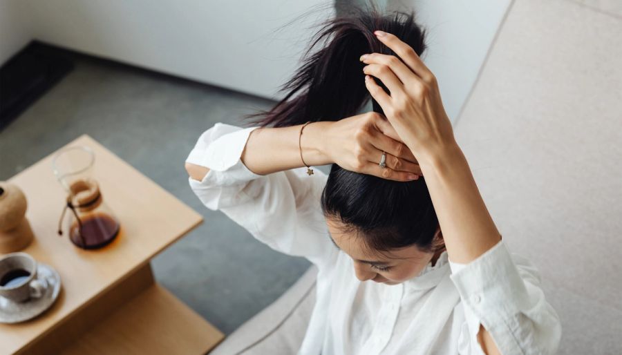 Woman putting her hair into a ponytail