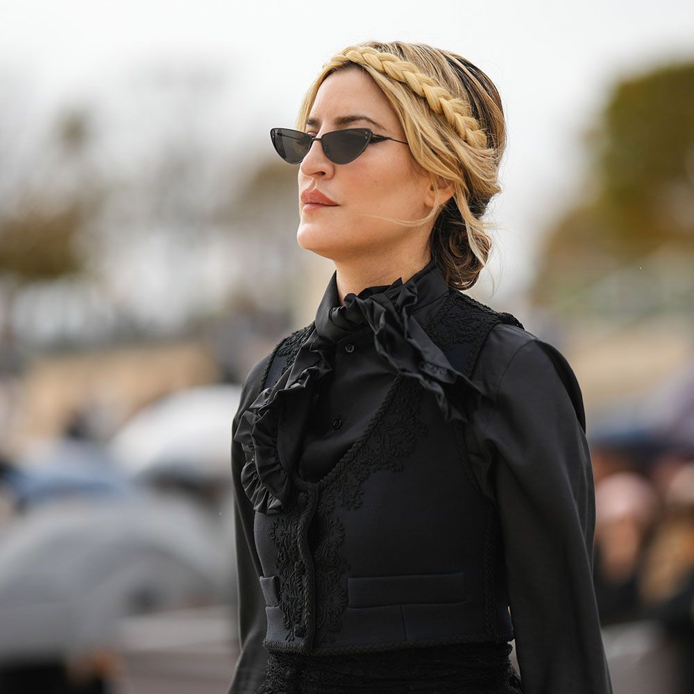 Woman with braided crown hairstyle wears sunglasses and all-black outfit 