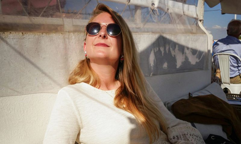 woman with long hair sitting on a boat in the sun
