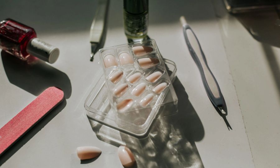 package of press-on nails surronded by nail file and other nail tools