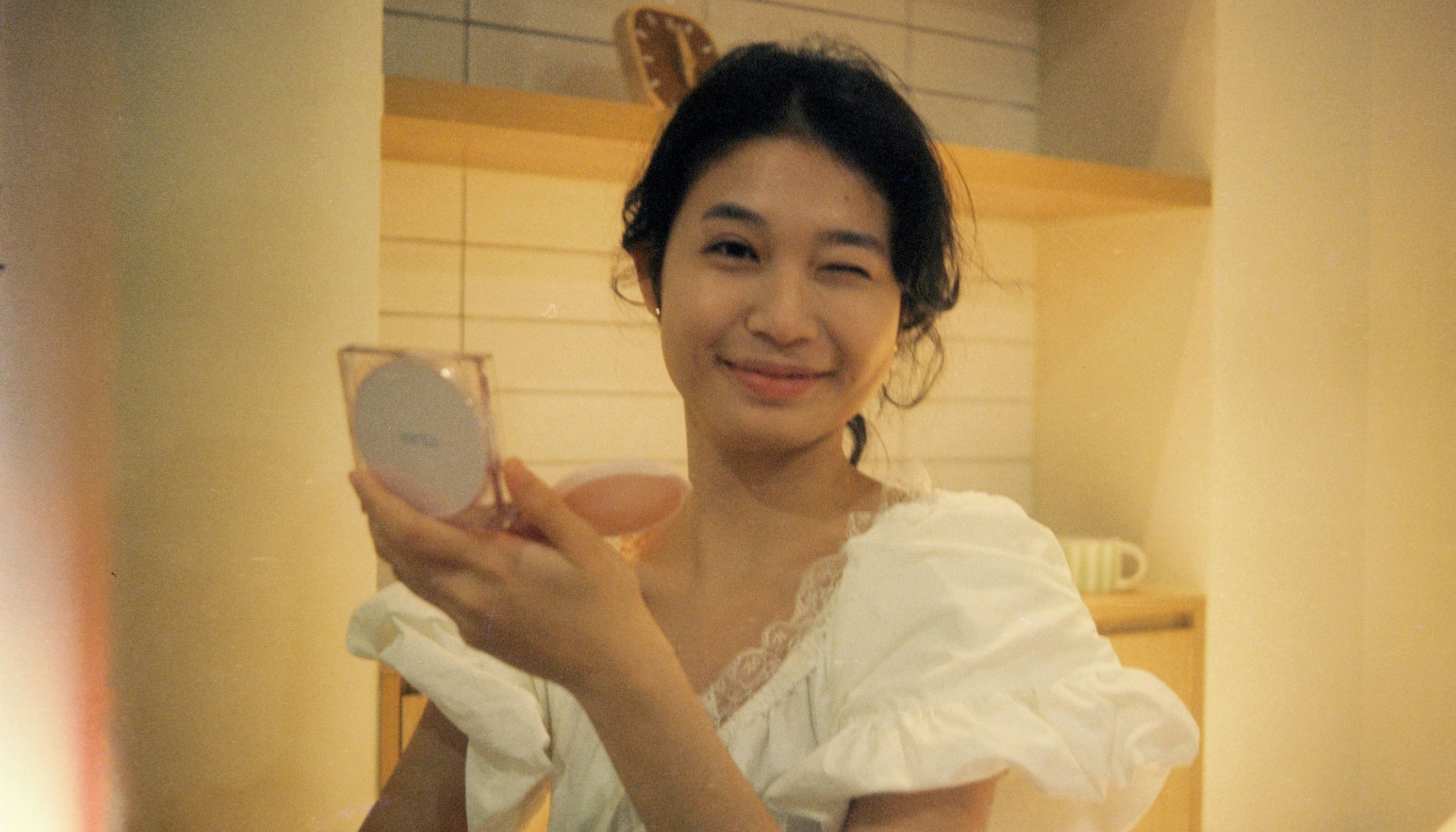 Woman applying cushion sunscreen, which is trending as a convenient method of SPF application in 2026
