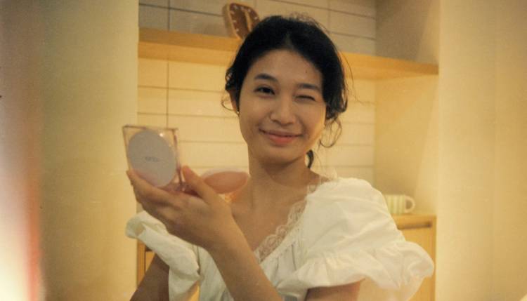 Woman applying cushion sunscreen, which is trending as a convenient method of SPF application in 2026
