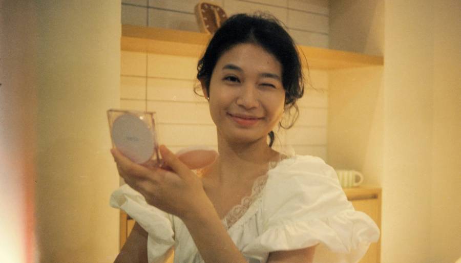 Woman applying cushion sunscreen, which is trending as a convenient method of SPF application in 2026