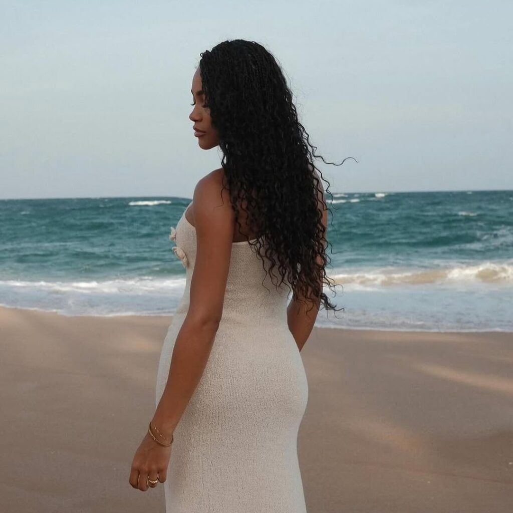 woman wears goddess braids in front of the ocean