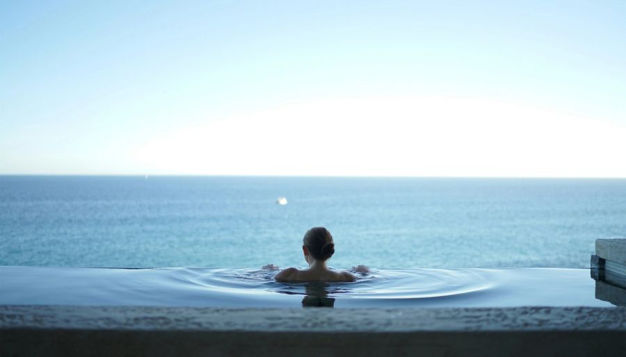 woman in a pool overlooking the ocean