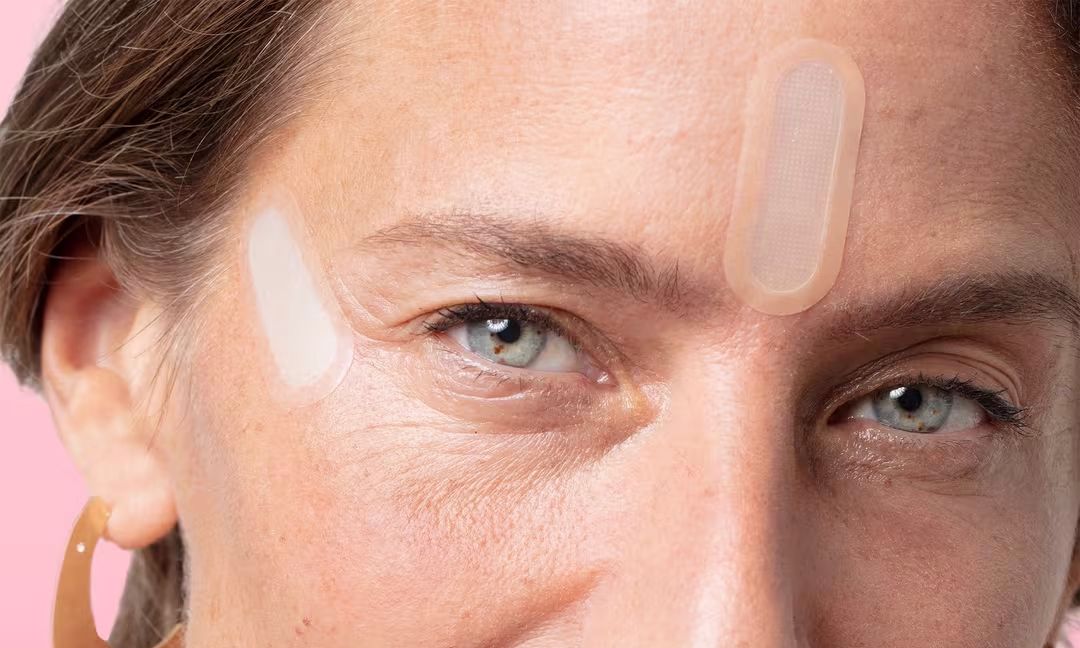 woman with Peace Out Wrinkles patches on crow's feet and forehead