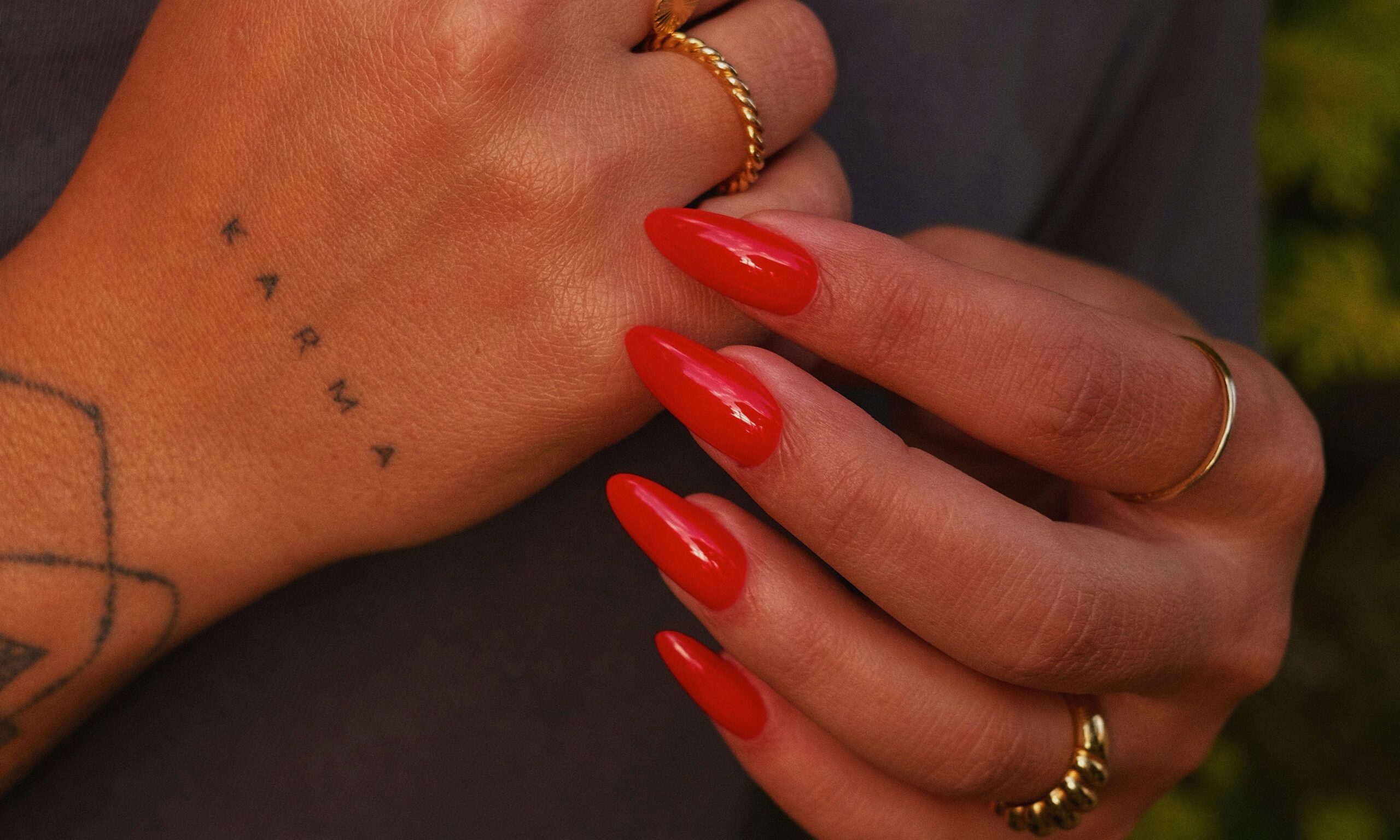 orange nails on tattooed hands