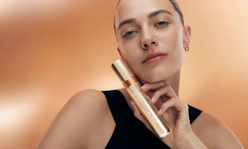 Model with a bottle of Augustinus Bader's The Elixir