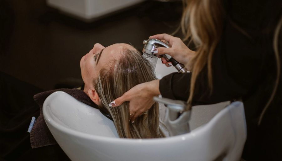 woman getting her hair washed and colored in the salon