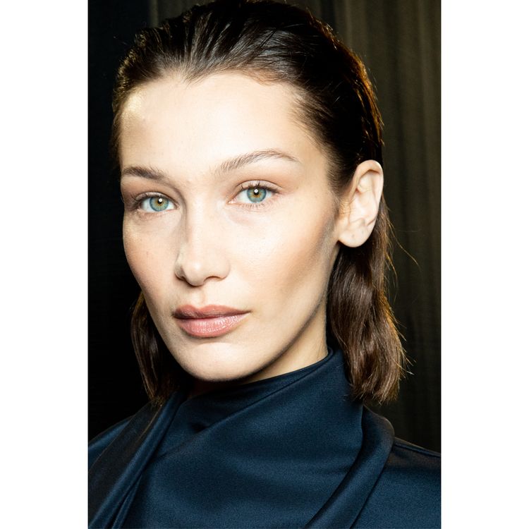 Close view of Bella Hadid with navy high-neck blouse and short hair