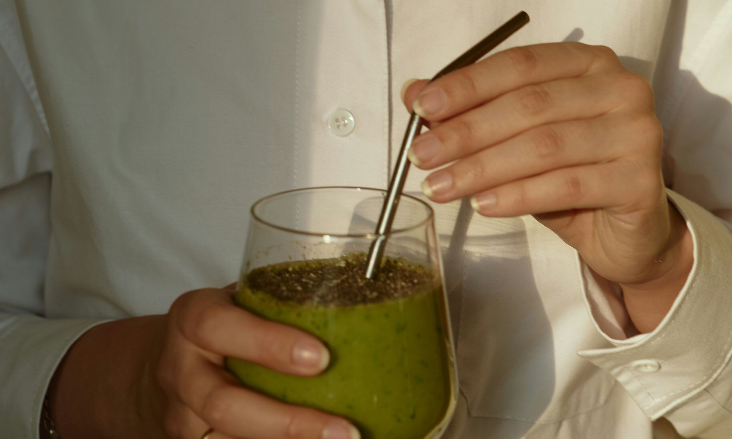 woman's hands holding healthy green drinks