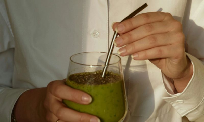 woman's hands holding healthy green drinks