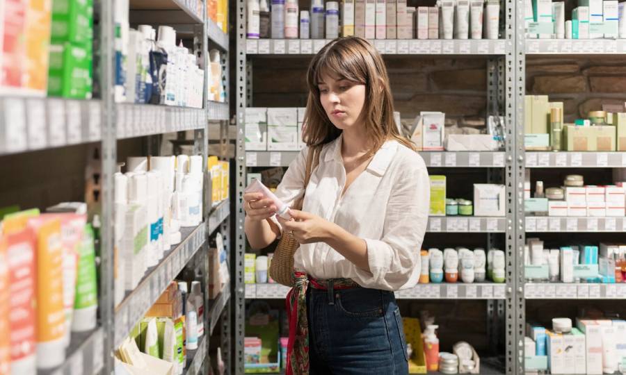 Young woman trying skin cream in grocery store