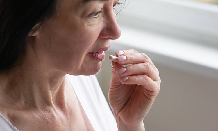 Middle-aged woman takes hormonal pills, aging beautifully