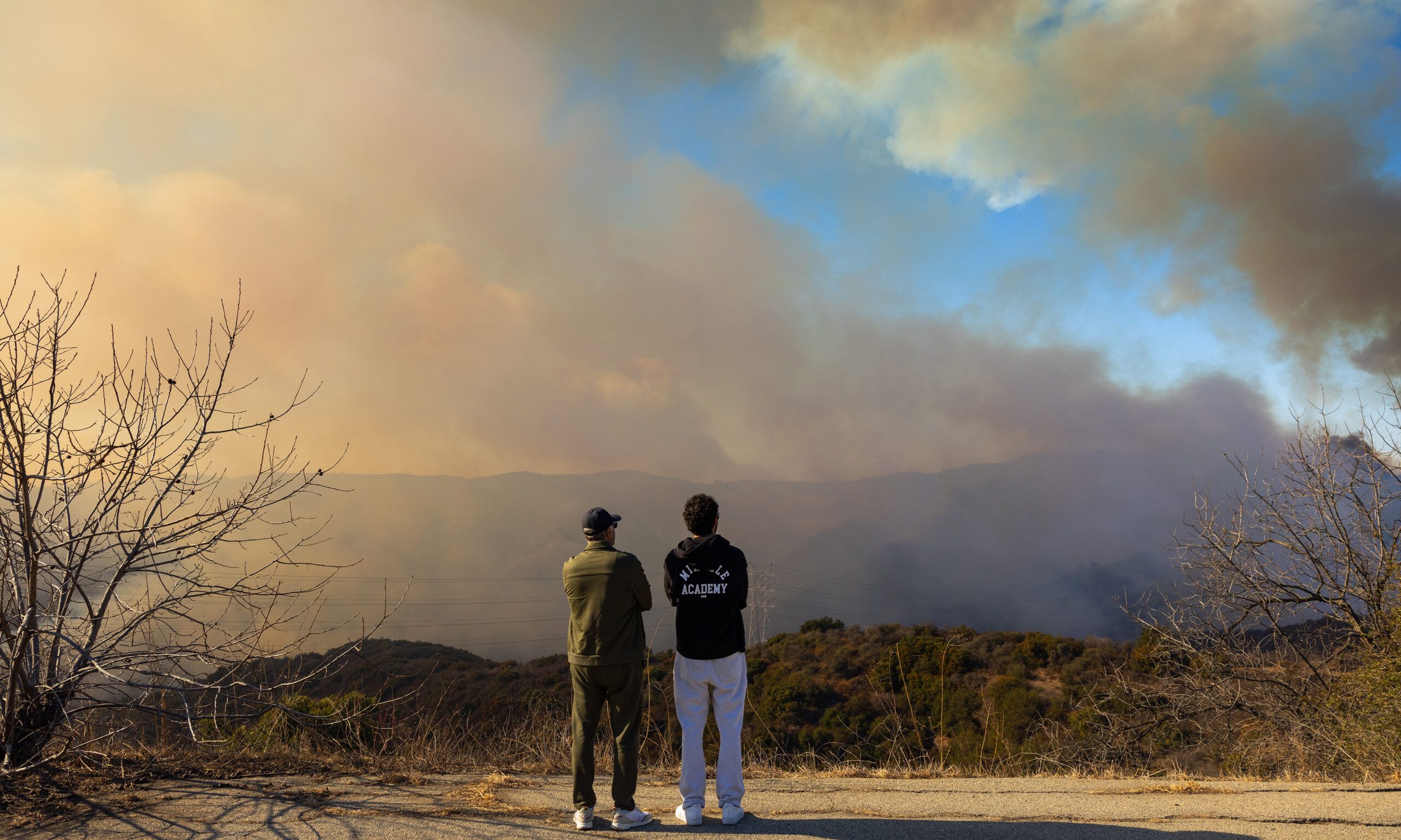 Civilians watch the Palisades Fire, along Mandeville Canyon, photographed from the Mountaingate development, above Mandeville, January 11, 2025, in the Brentwood community of Los Angeles, California.