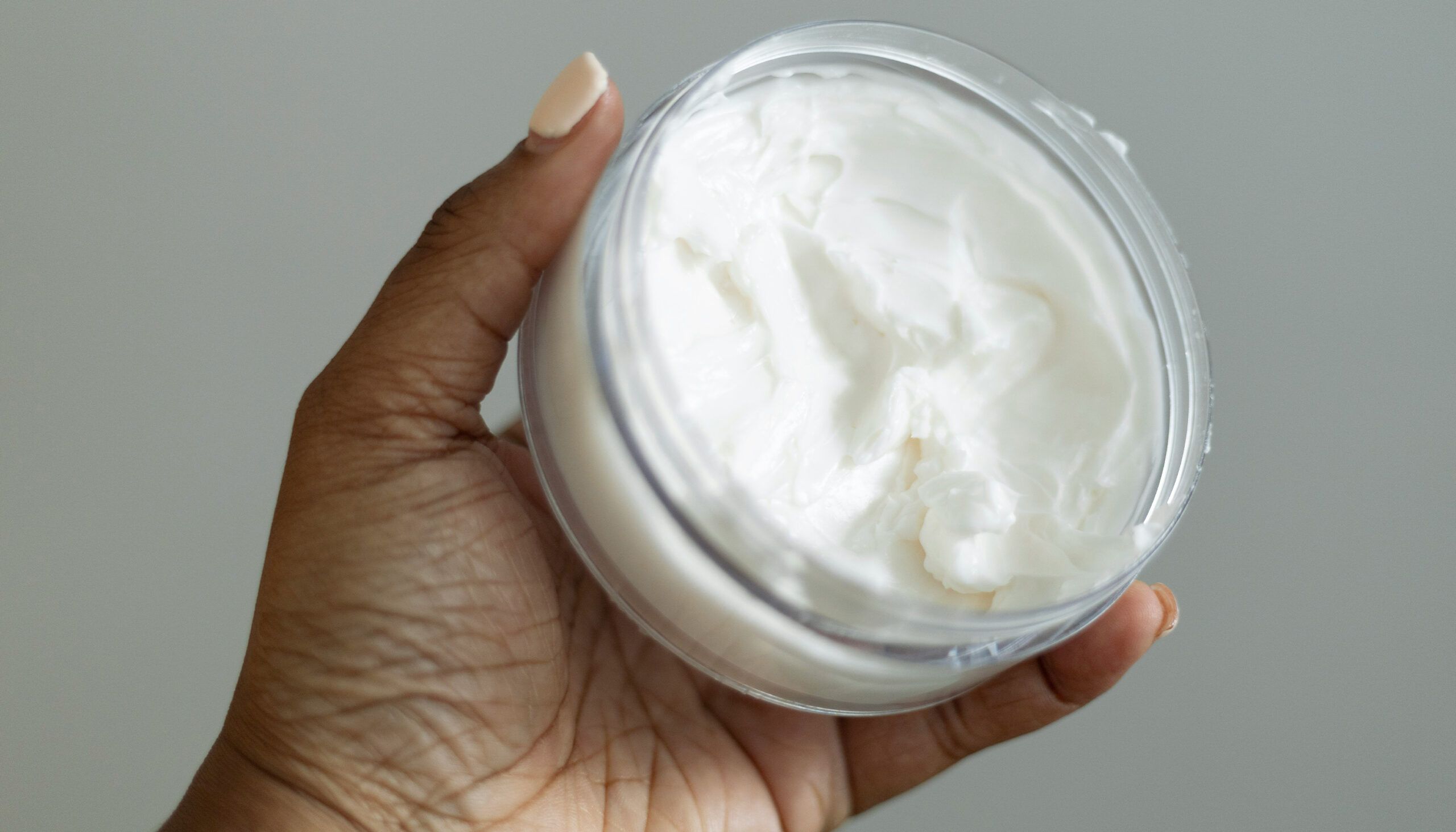 woman holding body lotion